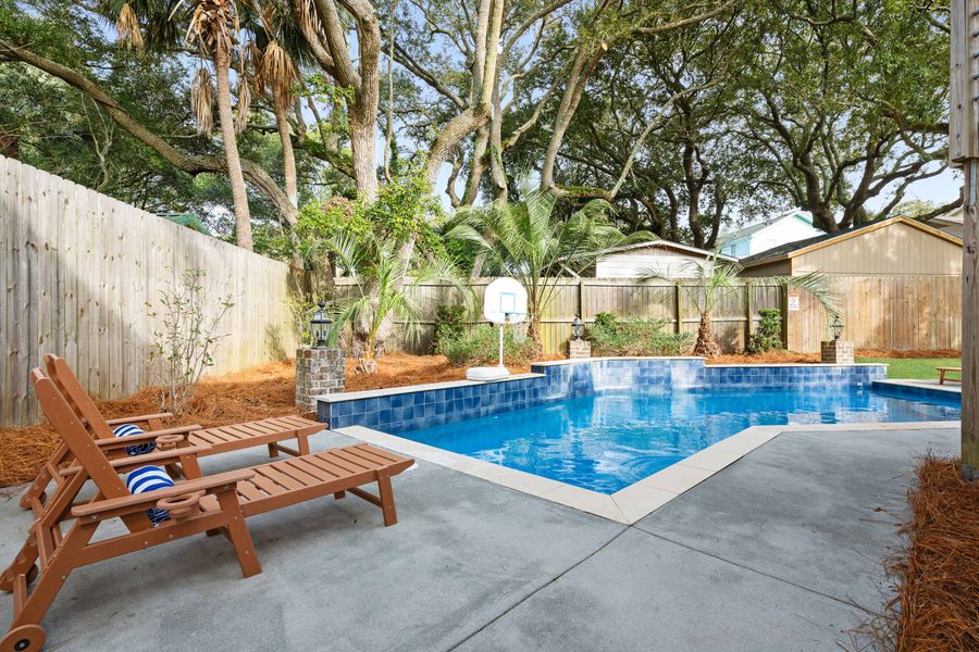 Four lounge chairs by the pool for relaxing. 