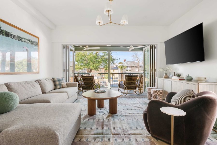 Welcome to your downtown Charleston rental! 4 Bedrooms + 4 Bathrooms. The pictured living room is spacious and has folding doors that open to the porch!  