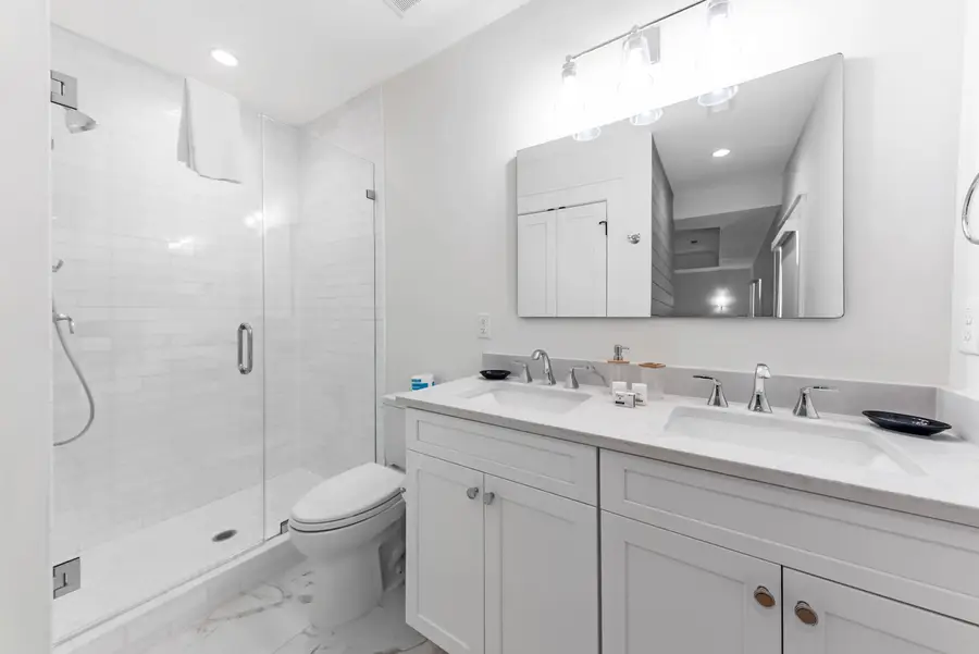 Master ensuite bathroom featuring a double vanity and spacious walk-in shower.