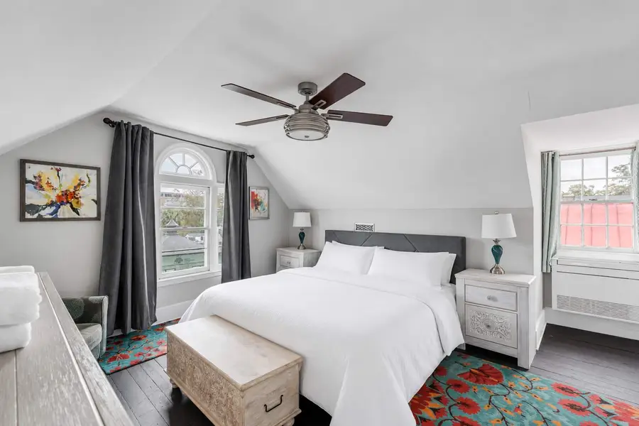 Bedroom 1: King bedroom with a ceiling fan and cozy seating area for relaxation.