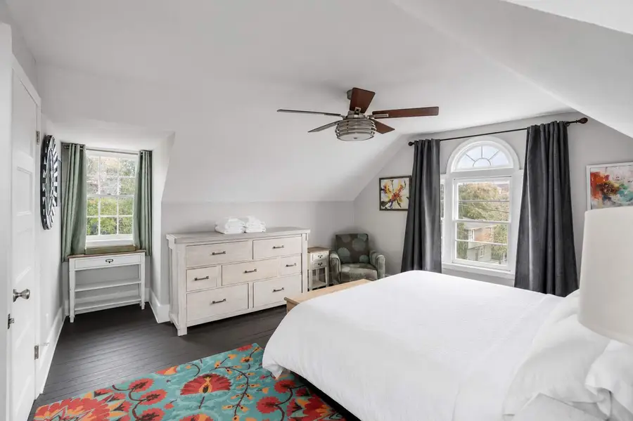 Bedroom 1: King bedroom with a ceiling fan and cozy seating area for relaxation.