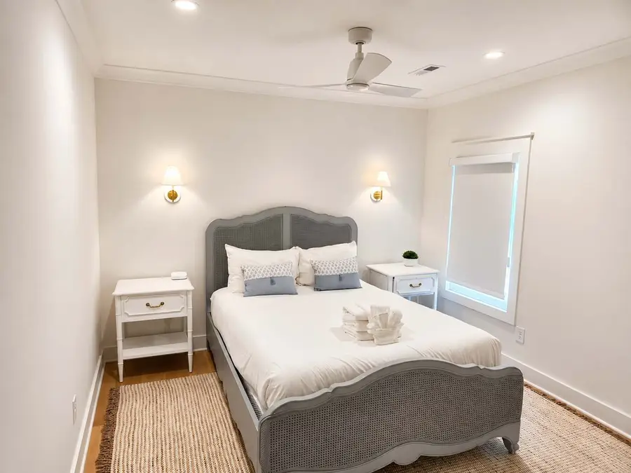 Bedroom 2: Relax in comfort with a queen bed, statement mirror, and natural light.
