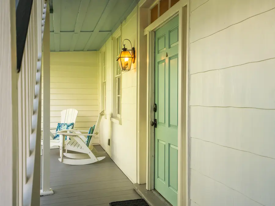 Two rocking chairs await on the porch, offering the perfect place to relax and take in the tranquil surroundings.
