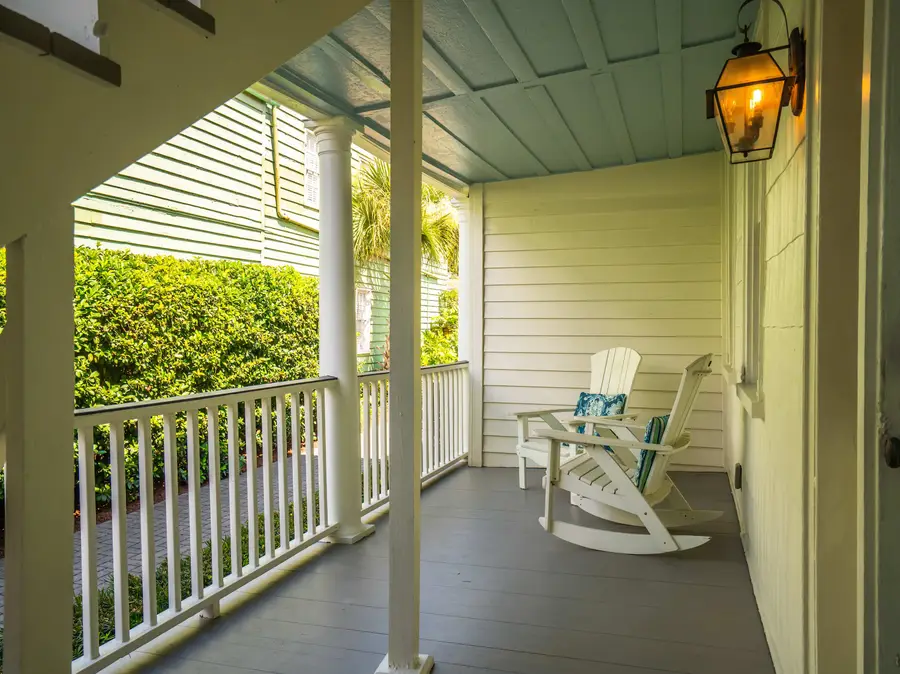 Two rocking chairs await on the porch, offering the perfect place to relax and take in the tranquil surroundings.