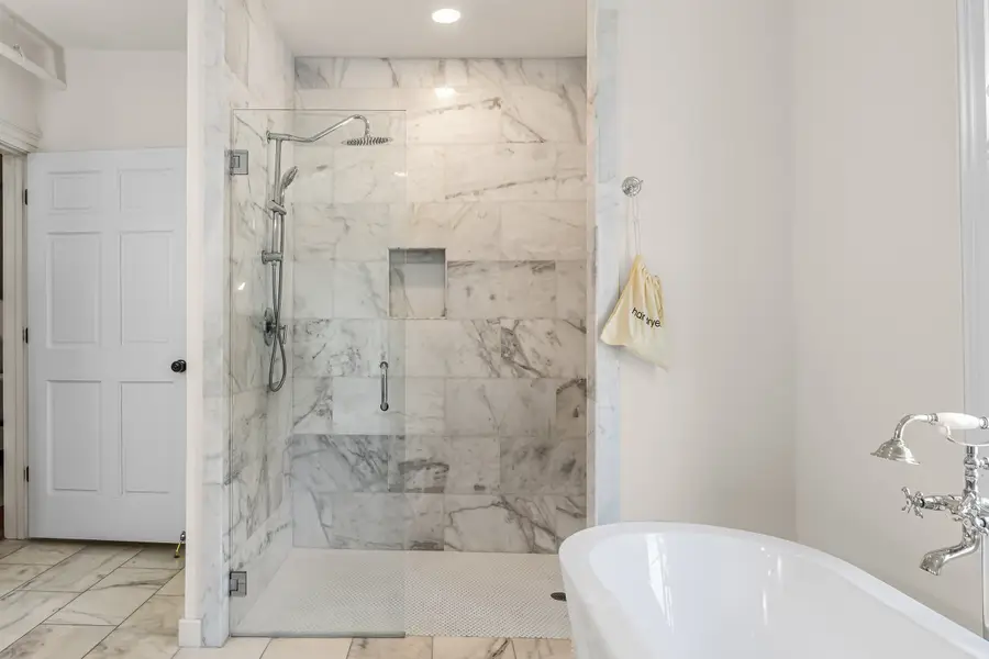 Bathroom #1: Indulge in a spa-like retreat featuring a soaking tub, walk-in shower, dual vanities, plush bathrobes, and elegant luxury finishes.