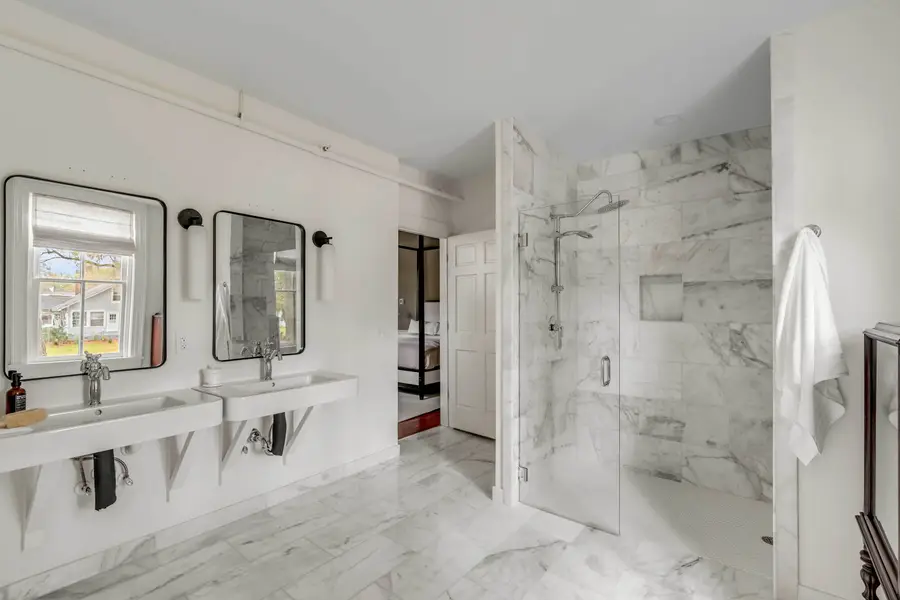 Bathroom #1: Indulge in a spa-like retreat featuring a soaking tub, walk-in shower, dual vanities, plush bathrobes, and elegant luxury finishes.