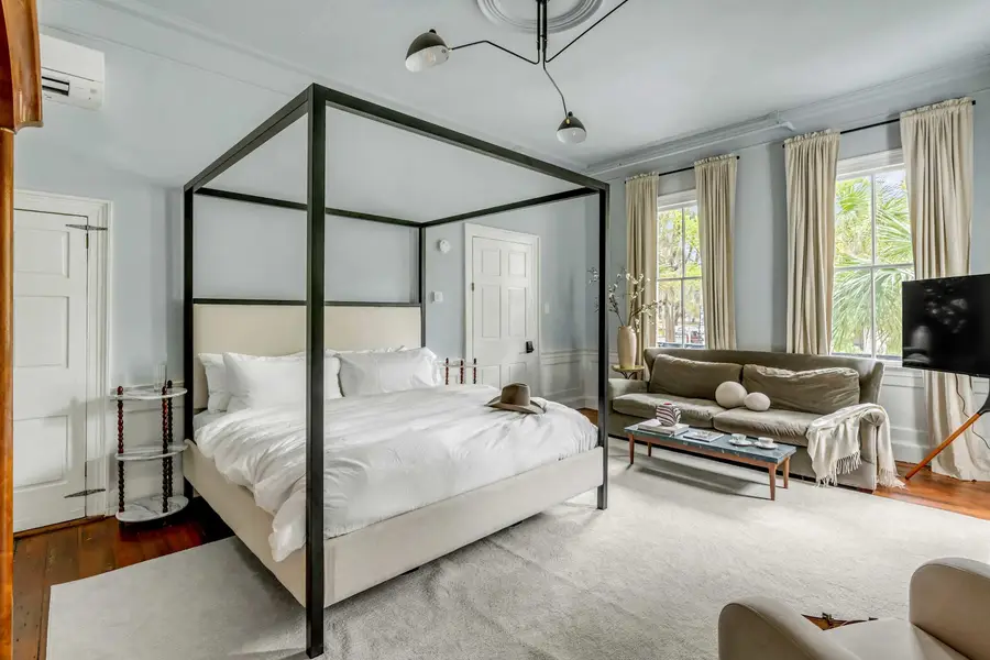 Bedroom #1: Bright, elegant, and inviting, this king suite offers a plush bed, cozy sofa, TV, and plenty of natural light for a truly relaxing stay.