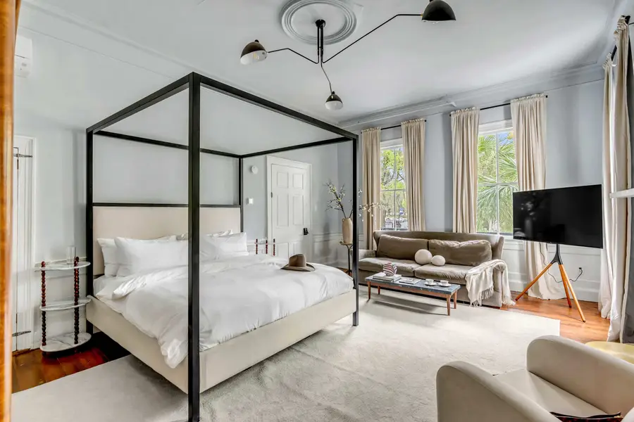 Bedroom #1: Bright, elegant, and inviting, this king suite offers a plush bed, cozy sofa, TV, and plenty of natural light for a truly relaxing stay.