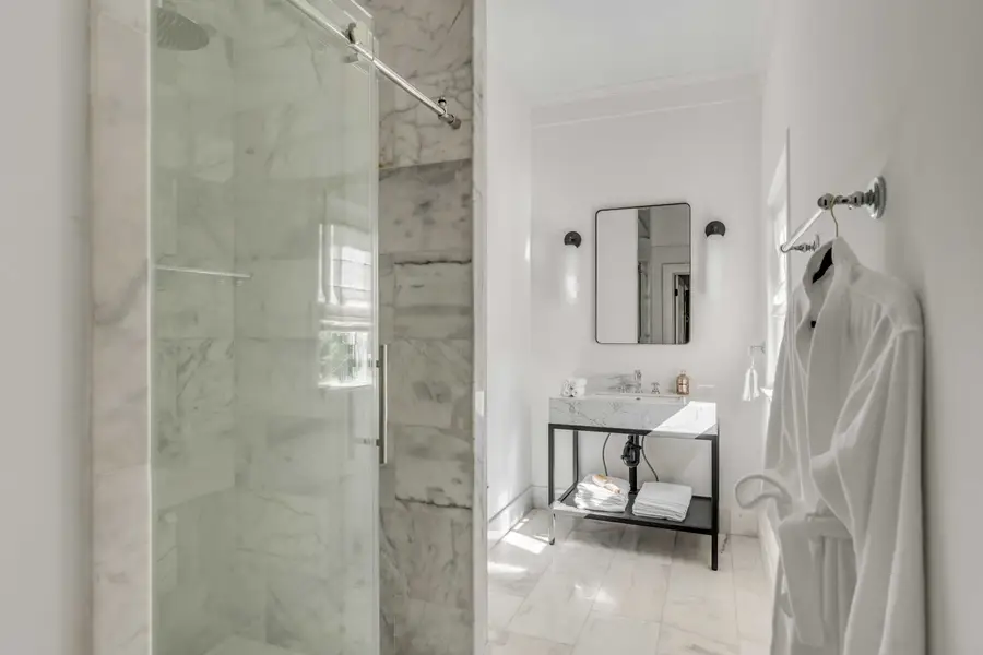 Bathroom #1: Indulge in a spa-like retreat featuring a walk-in shower, plush bathrobes, and elegant luxury finishes.
