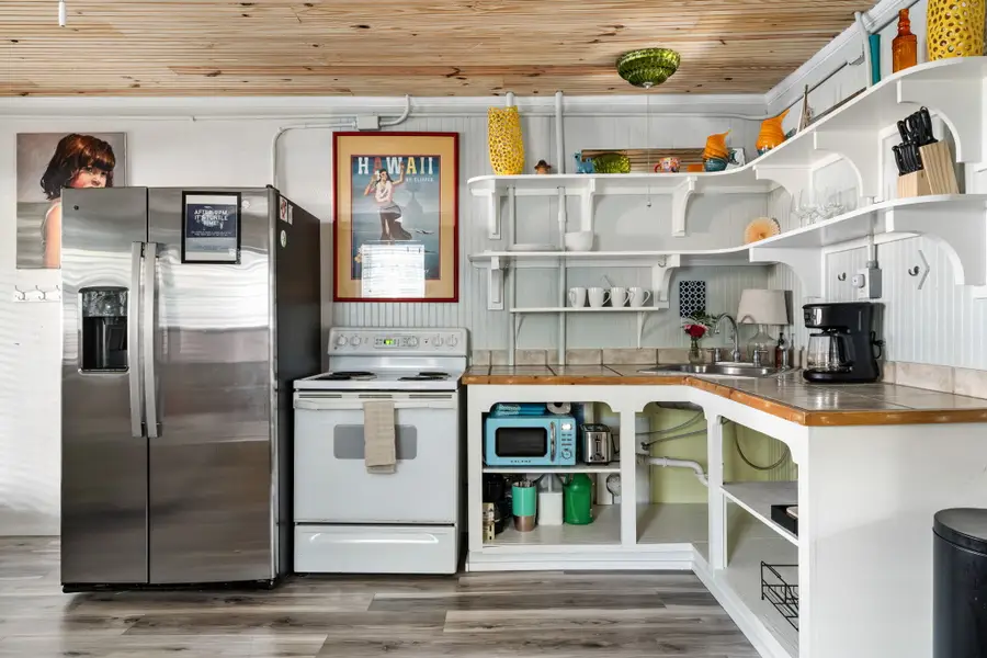 Cook with ease in the fully equipped kitchen featuring a full size refrigerator, stove, oven, microwave, dishwasher, coffee maker, toaster, blender, and all the cooking essentials.