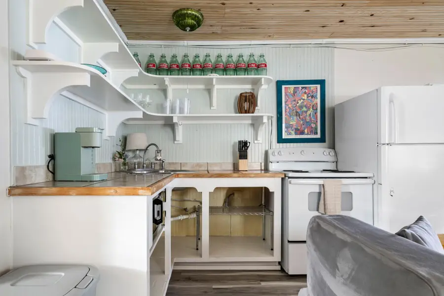 Cook with ease in the fully equipped kitchen featuring a full size refrigerator, stove, oven, microwave, dishwasher, coffee maker, toaster, blender, and all the cooking essentials.