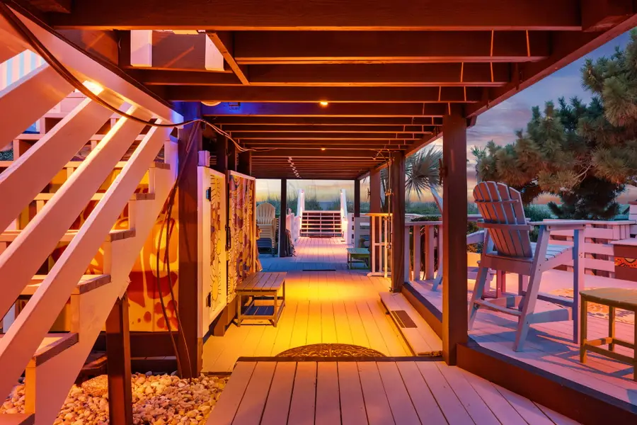 Enjoy endless outdoor living with spacious dining and lounge areas, cornhole, a hanging sofa, egg chair, lounge chairs, and a grill, all just steps from the beach.