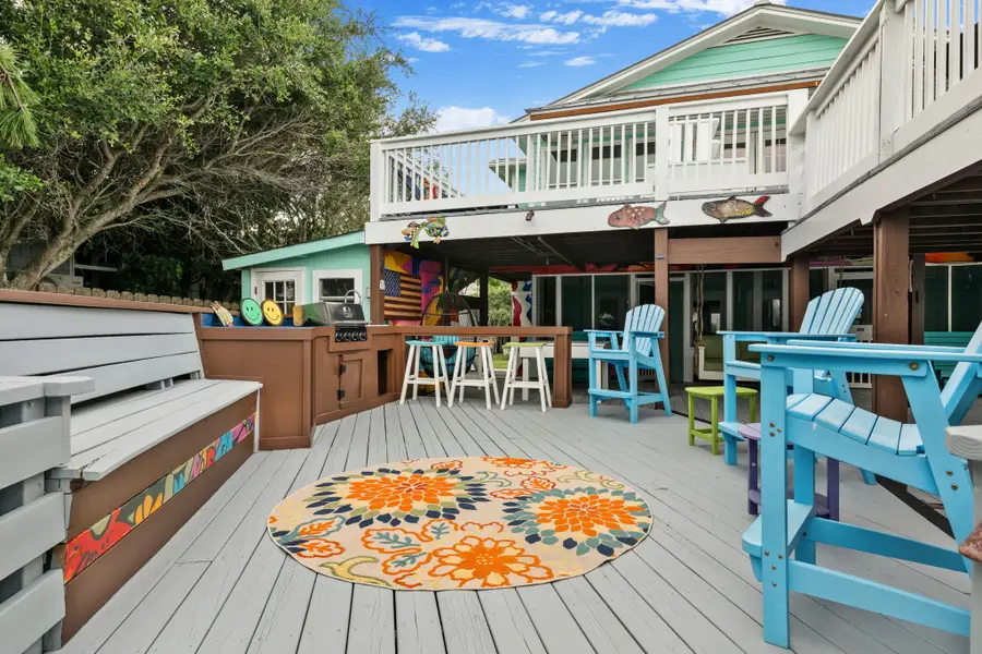 Enjoy endless outdoor living with spacious dining and lounge areas, cornhole, a hanging sofa, egg chair, lounge chairs, and a grill, all just steps from the beach.
