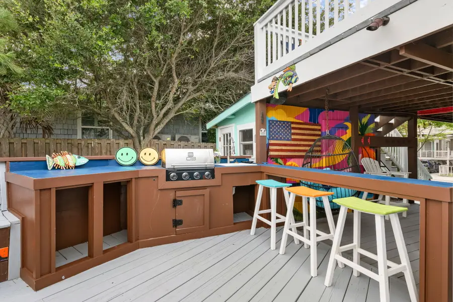 Enjoy endless outdoor living with spacious dining and lounge areas, cornhole, a hanging sofa, egg chair, lounge chairs, and a grill, all just steps from the beach.