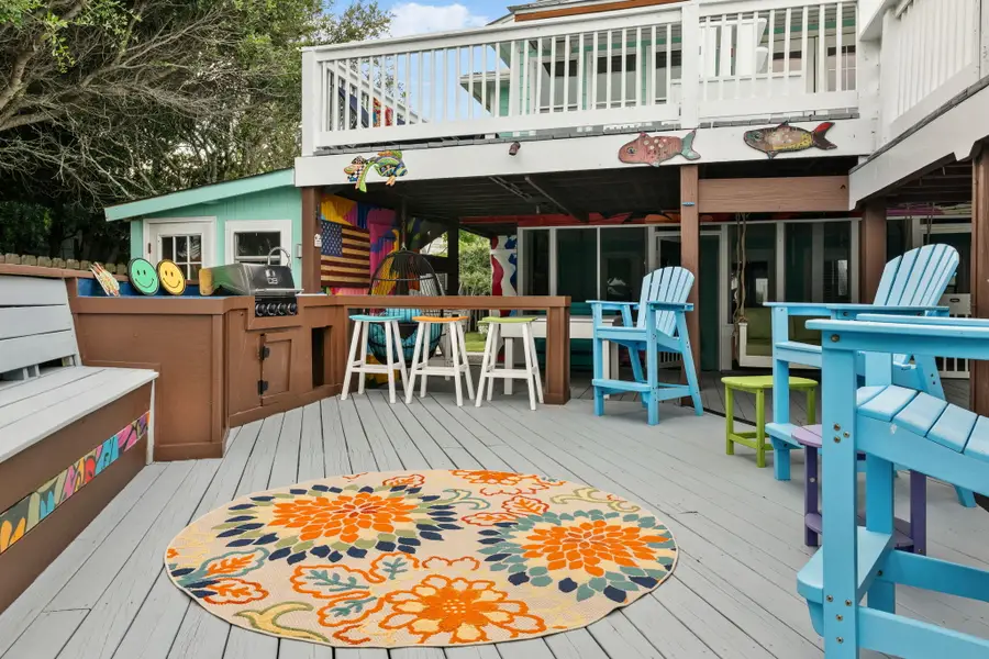 Enjoy endless outdoor living with spacious dining and lounge areas, cornhole, a hanging sofa, egg chair, lounge chairs, and a grill, all just steps from the beach.