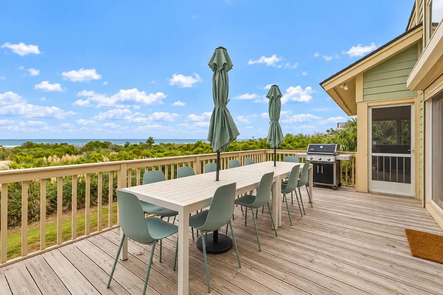 Back patio with beach views and plenty of dining seating for your group! There is a grill for cooking. 