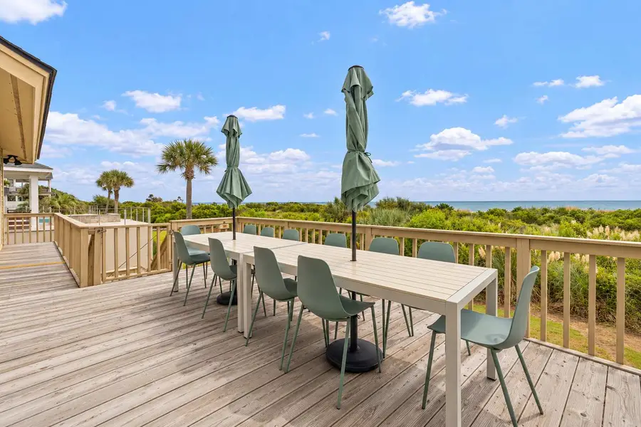 Back patio with beach views and plenty of dining seating for your group! There is a grill for cooking. 